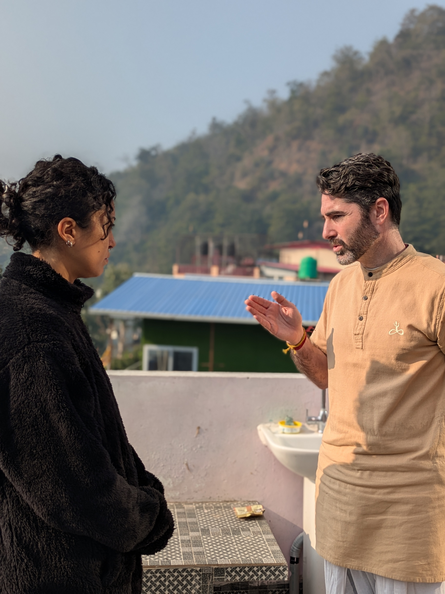 Baran in conversation with a student on a rooftop