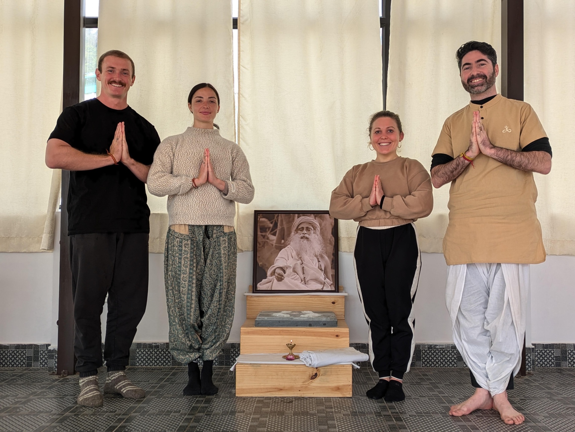 Group of students in namaskar with Sadhguru's portrait